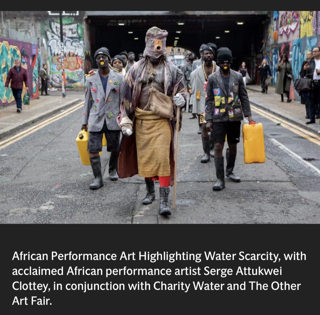 Image of a group dressed in abstractly designed outfits holding jerry cans in an urban street.